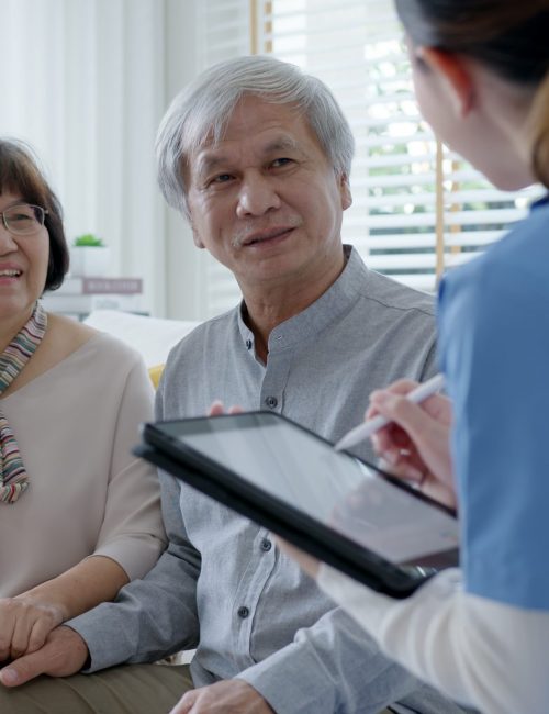 Young asia female nurse, assisted living, in-home carer or doctor visit old senior citizen at home talk about result follow up checklist, health care advice or prescription online on tablet computer.